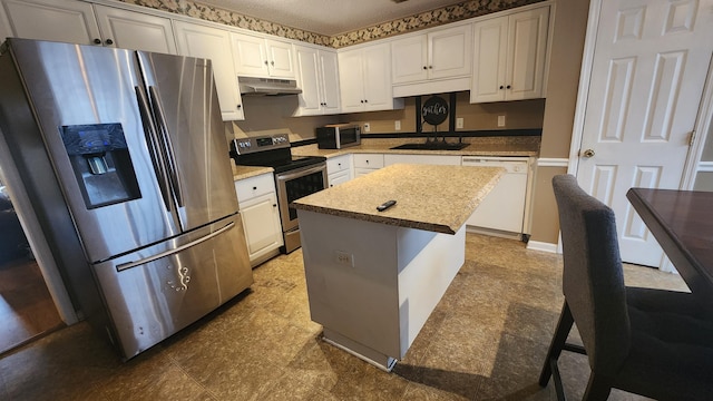 kitchen featuring white cabinets, sink, a kitchen island, and appliances with stainless steel finishes