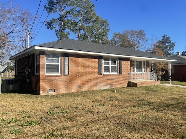 view of front of home with central AC, covered porch, and a front yard