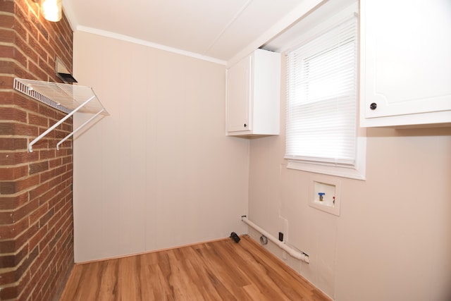 laundry area with cabinets, washer hookup, brick wall, crown molding, and light wood-type flooring