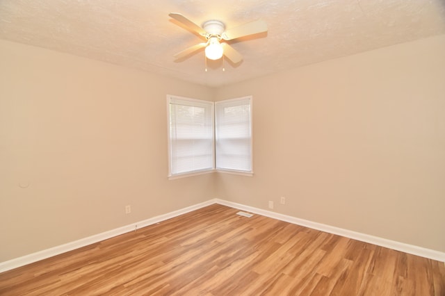 empty room featuring ceiling fan, a textured ceiling, and light hardwood / wood-style flooring