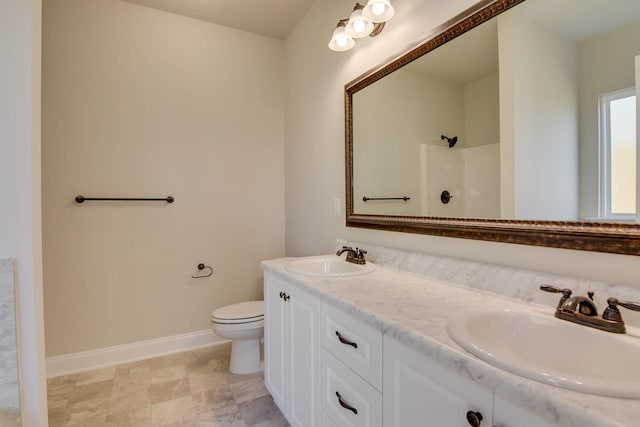 full bathroom featuring baseboards, a sink, toilet, and double vanity