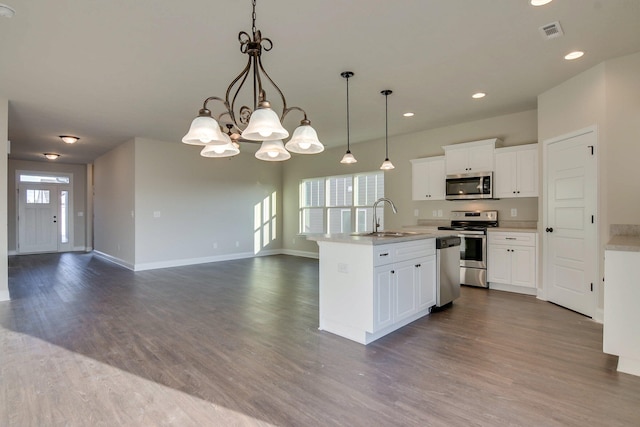 kitchen featuring visible vents, stainless steel appliances, dark wood finished floors, a sink, and a notable chandelier