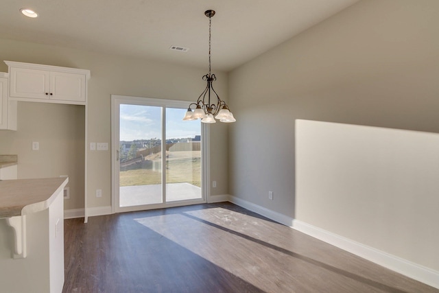 unfurnished dining area with baseboards, visible vents, dark wood-style flooring, an inviting chandelier, and recessed lighting