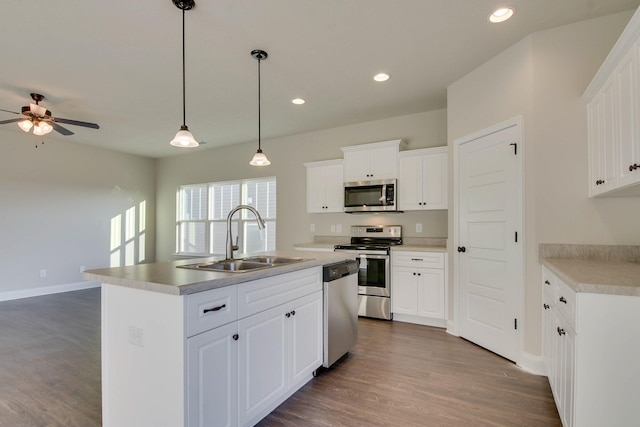 kitchen with a sink, white cabinetry, appliances with stainless steel finishes, dark wood-type flooring, and recessed lighting