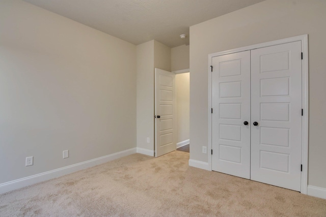 unfurnished bedroom featuring a closet, carpet flooring, and baseboards