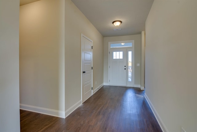 foyer featuring dark wood-type flooring, visible vents, and baseboards