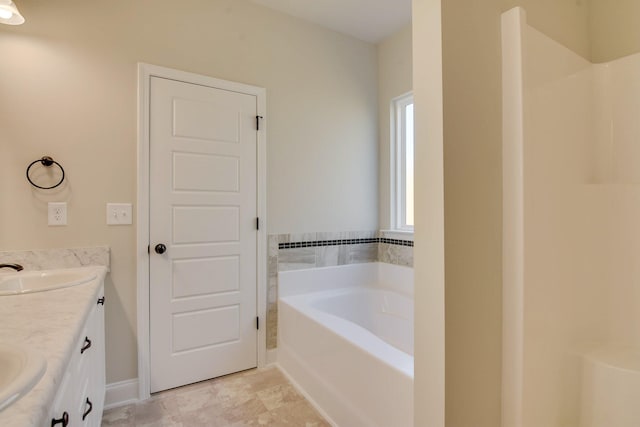 bathroom featuring a bath, double vanity, and a sink