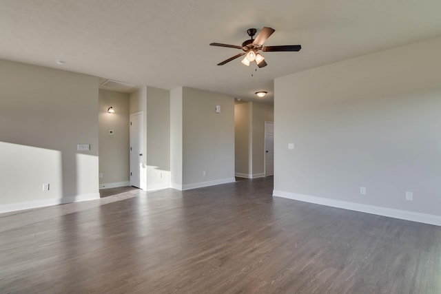 unfurnished room featuring dark wood finished floors, a ceiling fan, and baseboards