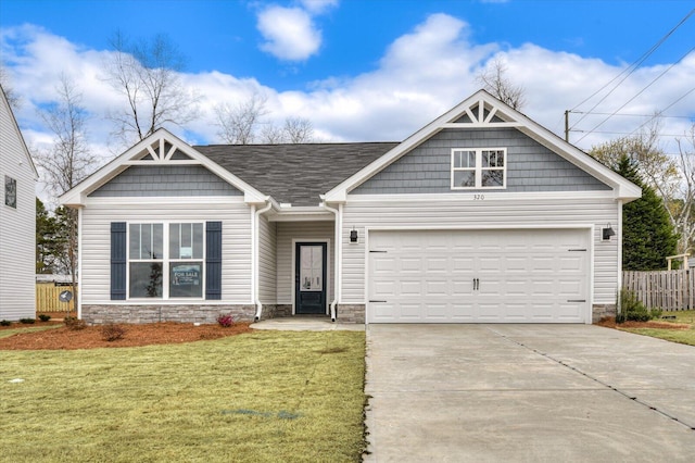 craftsman inspired home featuring stone siding, fence, an attached garage, concrete driveway, and a front lawn