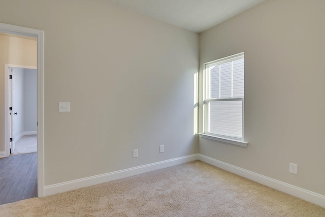 carpeted spare room with plenty of natural light and baseboards