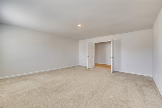 unfurnished room with recessed lighting, light colored carpet, and baseboards