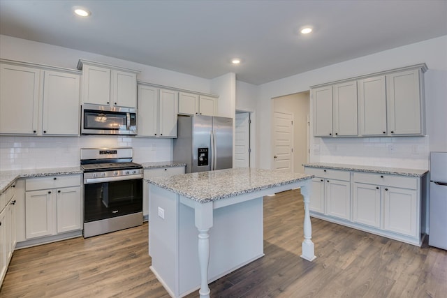 830 Otto Run, North Augusta, SC 29860 - kitchen featuring stainless steel appliances, tasteful backsplash, wood finished floors, a kitchen island, and light stone counters