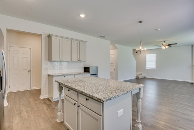 830 Otto Run, North Augusta, SC 29860 - kitchen with a kitchen bar, wood finished floors, decorative backsplash, a center island, and baseboards