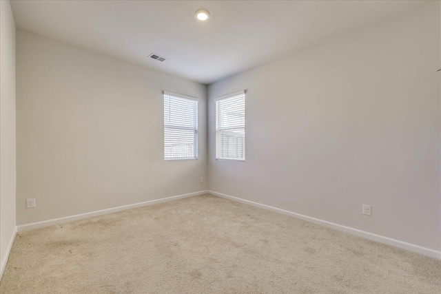 unfurnished room featuring light carpet, baseboards, and visible vents