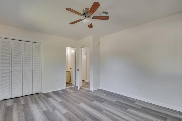 unfurnished bedroom featuring ceiling fan, light wood-type flooring, and a closet