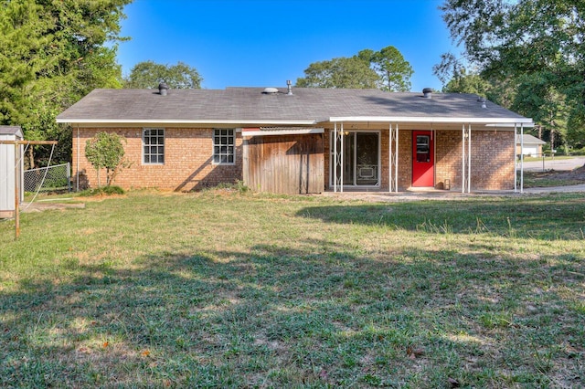 rear view of house featuring a yard