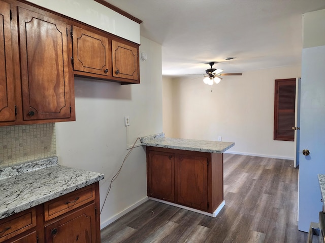 kitchen featuring ceiling fan, kitchen peninsula, dark wood-type flooring, and tasteful backsplash