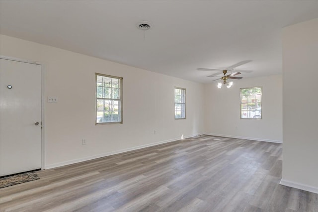 empty room with ceiling fan and light hardwood / wood-style flooring