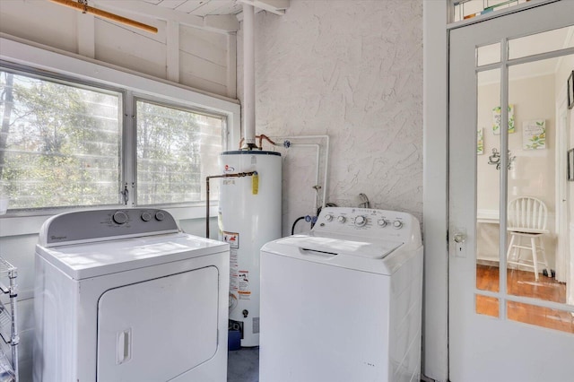 laundry area with washer and dryer, a wealth of natural light, and water heater