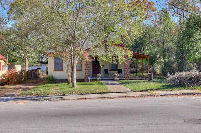 obstructed view of property featuring covered porch and a front yard