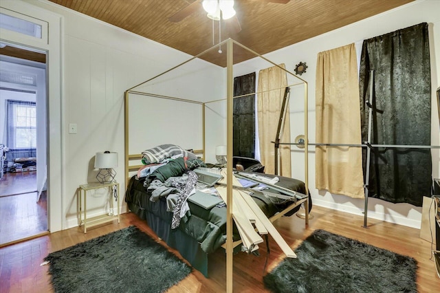 bedroom featuring ceiling fan, wood-type flooring, and wooden ceiling