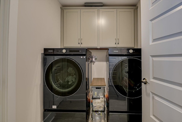 laundry area with washer and clothes dryer and cabinets