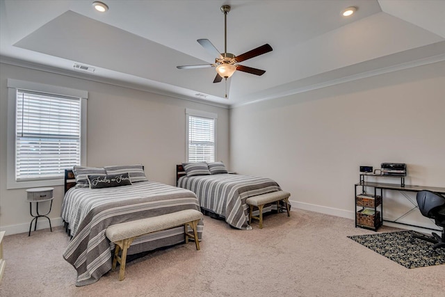 bedroom with a raised ceiling, ceiling fan, carpet flooring, and crown molding