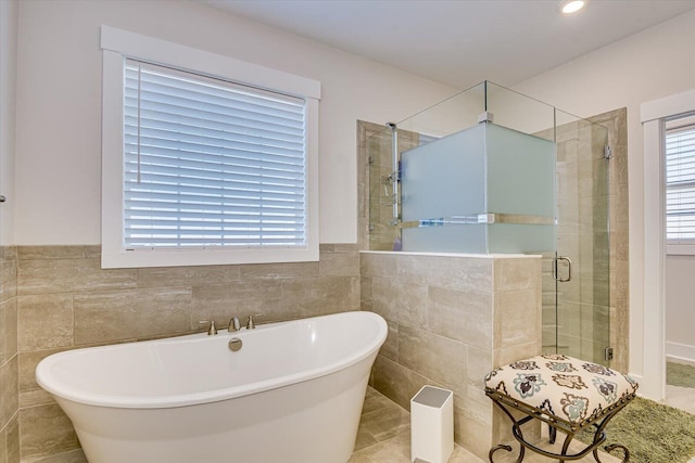 bathroom with tile patterned floors, tile walls, and independent shower and bath