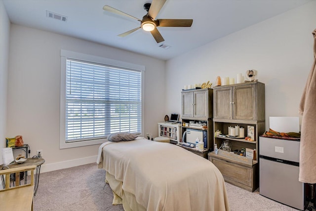 carpeted bedroom with stainless steel refrigerator and ceiling fan