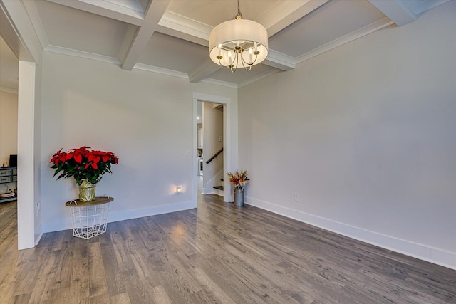 empty room with beam ceiling, coffered ceiling, a notable chandelier, hardwood / wood-style floors, and ornamental molding