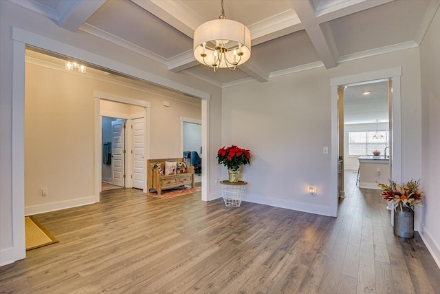 unfurnished room with coffered ceiling, crown molding, hardwood / wood-style flooring, beamed ceiling, and a notable chandelier