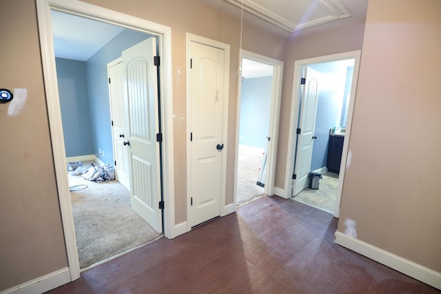 hallway with baseboards, carpet floors, attic access, and wood finished floors