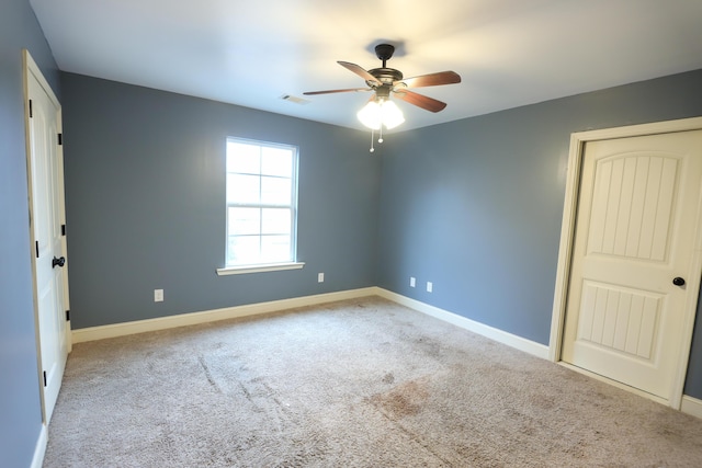 unfurnished bedroom featuring visible vents, baseboards, carpet, and a ceiling fan