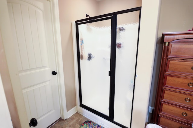 bathroom with baseboards and a stall shower