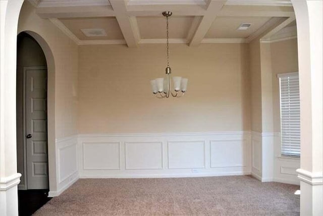 unfurnished room with carpet flooring, an inviting chandelier, and crown molding