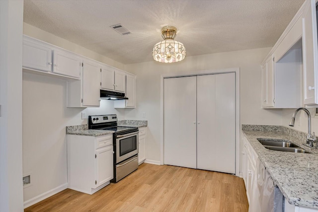 kitchen with decorative light fixtures, electric range, and white cabinetry