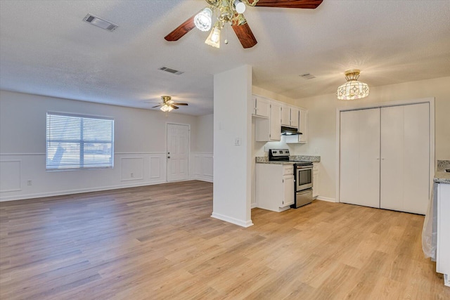 kitchen featuring stainless steel electric stove, white cabinets, a notable chandelier, and light hardwood / wood-style floors