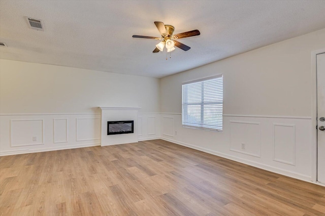 unfurnished living room with light hardwood / wood-style floors, a textured ceiling, and ceiling fan