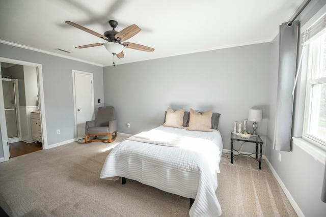 carpeted bedroom with ensuite bathroom, ceiling fan, and crown molding