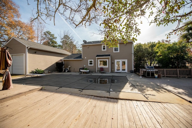 rear view of house with french doors and a covered pool