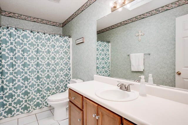 bathroom featuring toilet, a textured ceiling, vanity, wallpapered walls, and tile patterned flooring