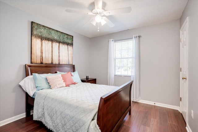 bedroom featuring baseboards, ceiling fan, wood finished floors, and a textured ceiling