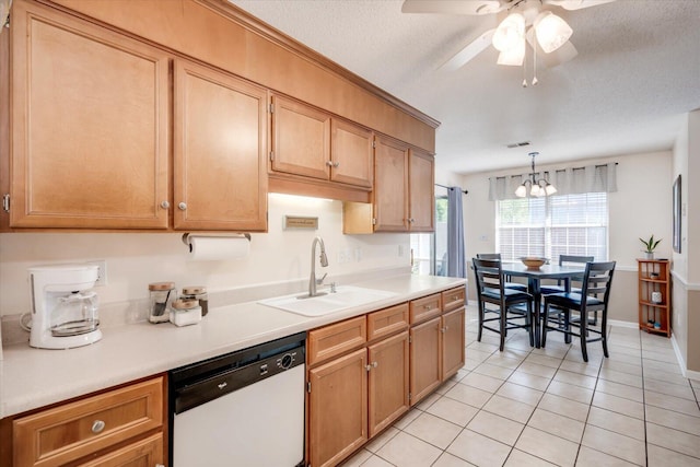 kitchen featuring ceiling fan with notable chandelier, light tile patterned floors, dishwasher, light countertops, and a sink