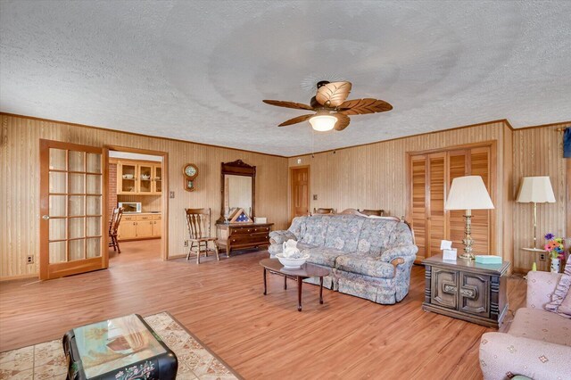 living room with a textured ceiling, hardwood / wood-style flooring, and ceiling fan