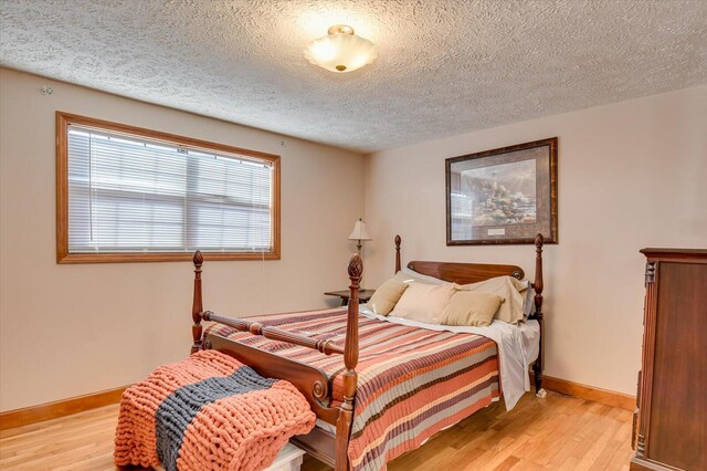 bedroom featuring a textured ceiling and light wood-type flooring