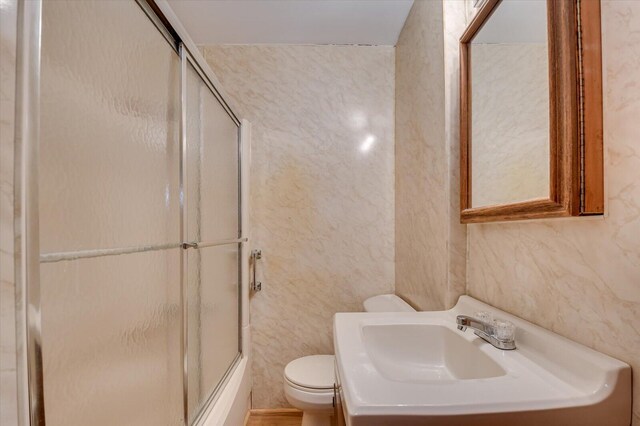 full bathroom with sink, enclosed tub / shower combo, and toilet