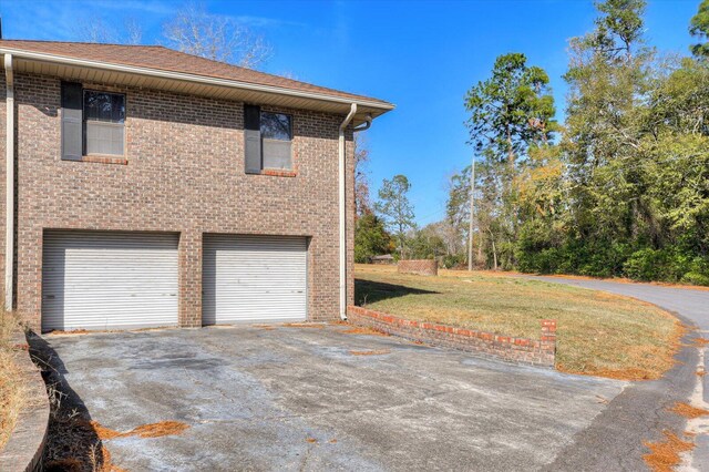 view of property exterior featuring a garage and a lawn