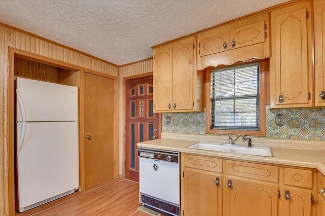 kitchen featuring sink, light wood-type flooring, a textured ceiling, white appliances, and ornamental molding