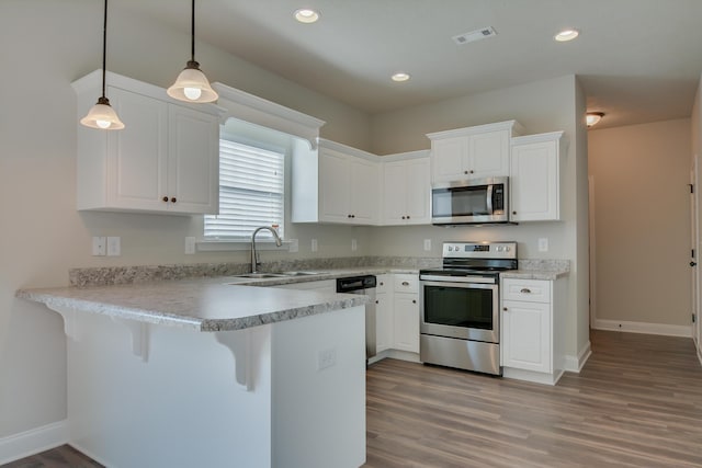 4062 Cottingham Way, Augusta, GA 30909 - kitchen with appliances with stainless steel finishes, a sink, a peninsula, white cabinetry, and light wood-style floors