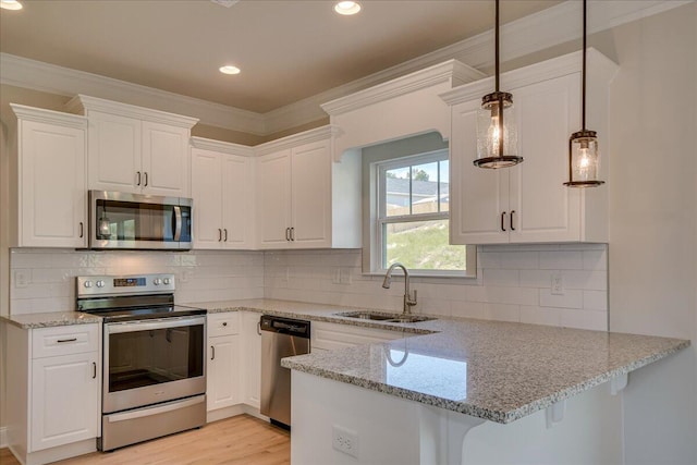 4062 Cottingham Way, Augusta, GA 30909 - kitchen with appliances with stainless steel finishes, a sink, crown molding, white cabinets, and a peninsula